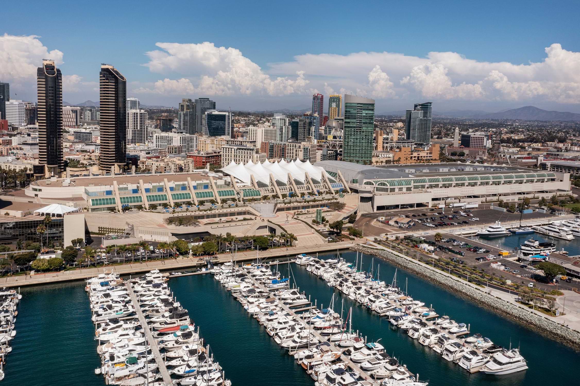 Exterior Image of the San Diego Convention Center building, with the bay and boats on one side and downtown skyline on the other.